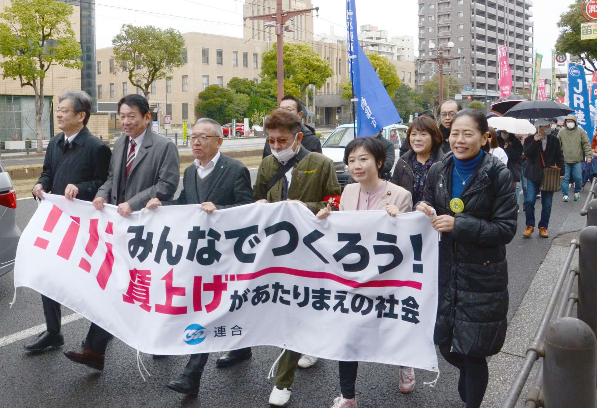 横断幕を掲げデモ行進する参加者＝８日、鹿児島市名山町