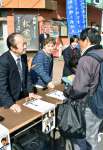 高校生と共に署名活動をする（左から）市川健一さんと龍子さん＝９日、伊佐市大口上町