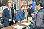 高校生と共に署名活動をする（左から）市川健一さんと龍子さん＝９日、伊佐市大口上町