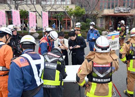 出火時の状況を聞く消防関係者ら＝１２日午後３時ごろ、鹿児島市与次郎１丁目