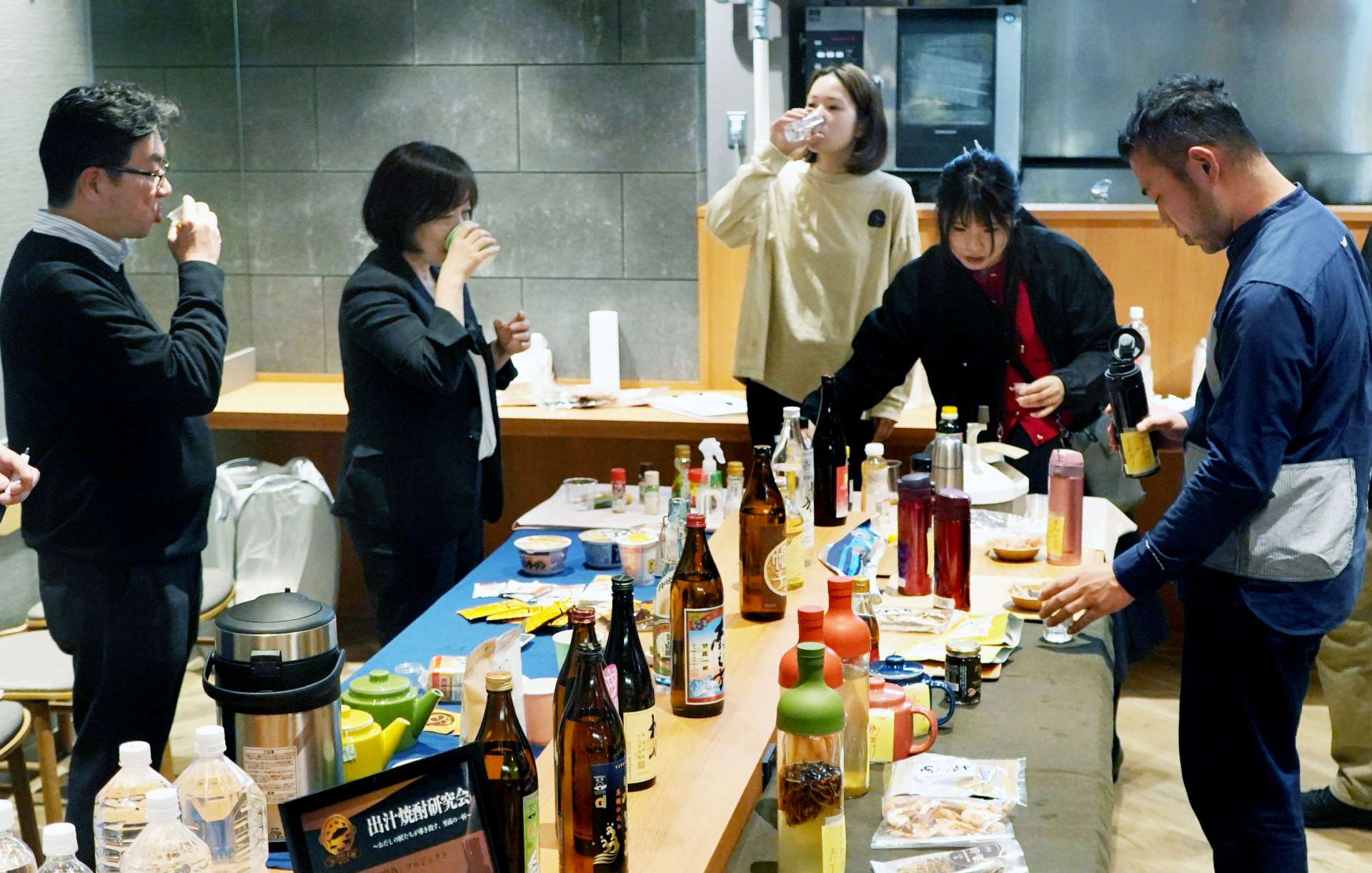 だしで割った焼酎を試飲する参加者ら＝１２日、鹿児島市千日町のセンテラス天文館
