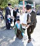 船の模型を持ち、境内を歩く男児ら＝いちき串木野市の羽島崎神社
