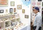 作品を眺める来場者＝１４日、鹿児島市のカクイックス交流センター