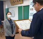 うそ電話詐欺被害を未然に防ぎ、表彰される長崎里歩さん（左）＝錦江町の錦江警察署