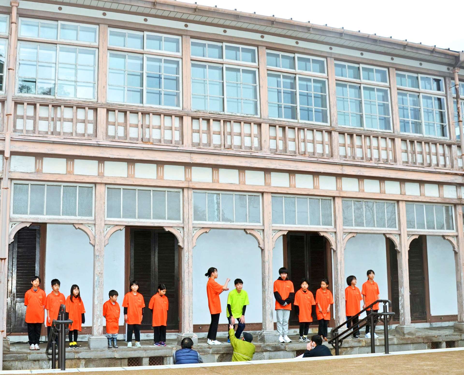 世界遺産「異人館」で、吉野を舞台にした狂言の朗読を披露する小中学生＝１５日、鹿児島市吉野町