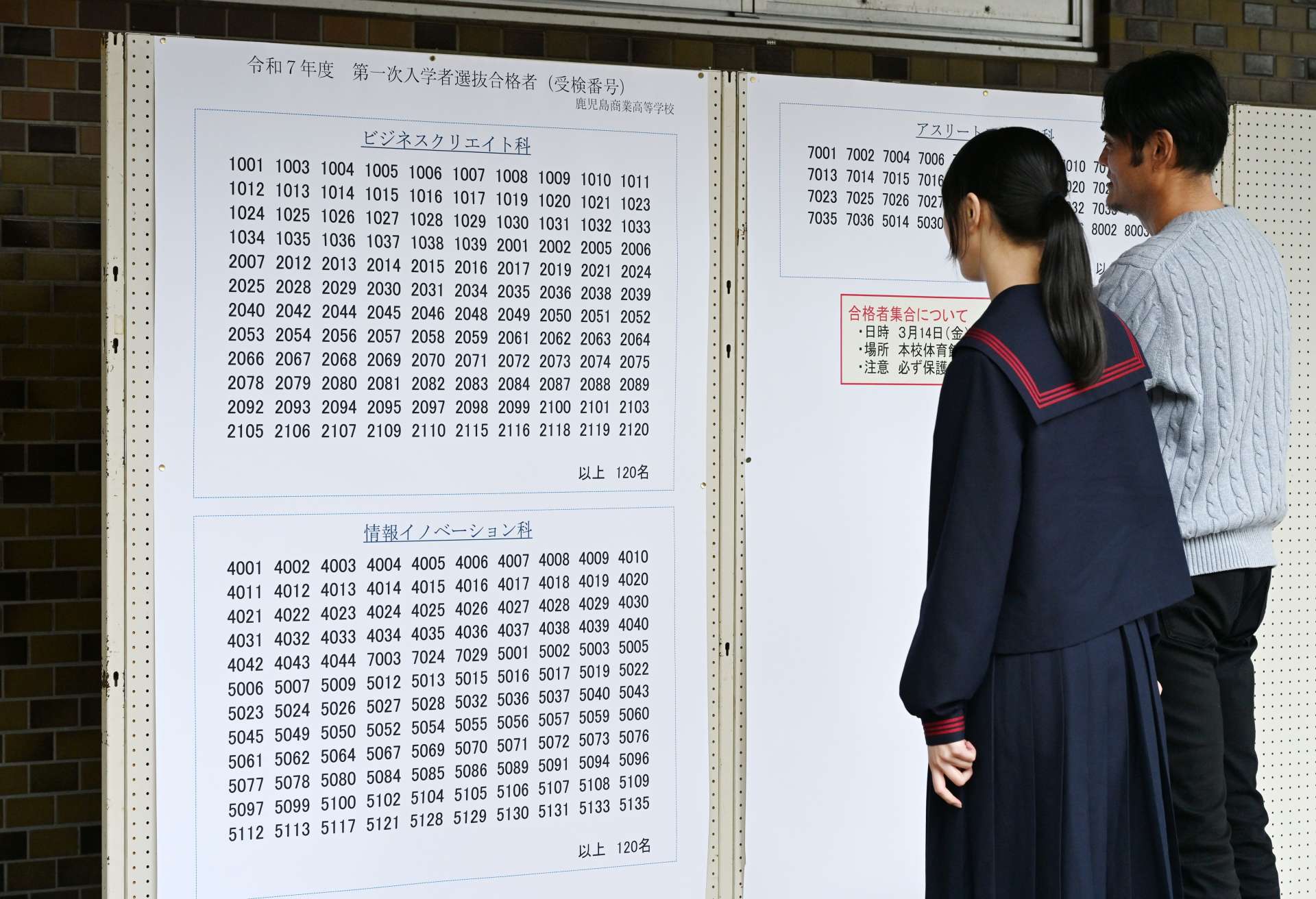 受験番号を確認する鹿児島商業高校の受験生。共学化、学科再編で定員割れを脱した＝鹿児島市