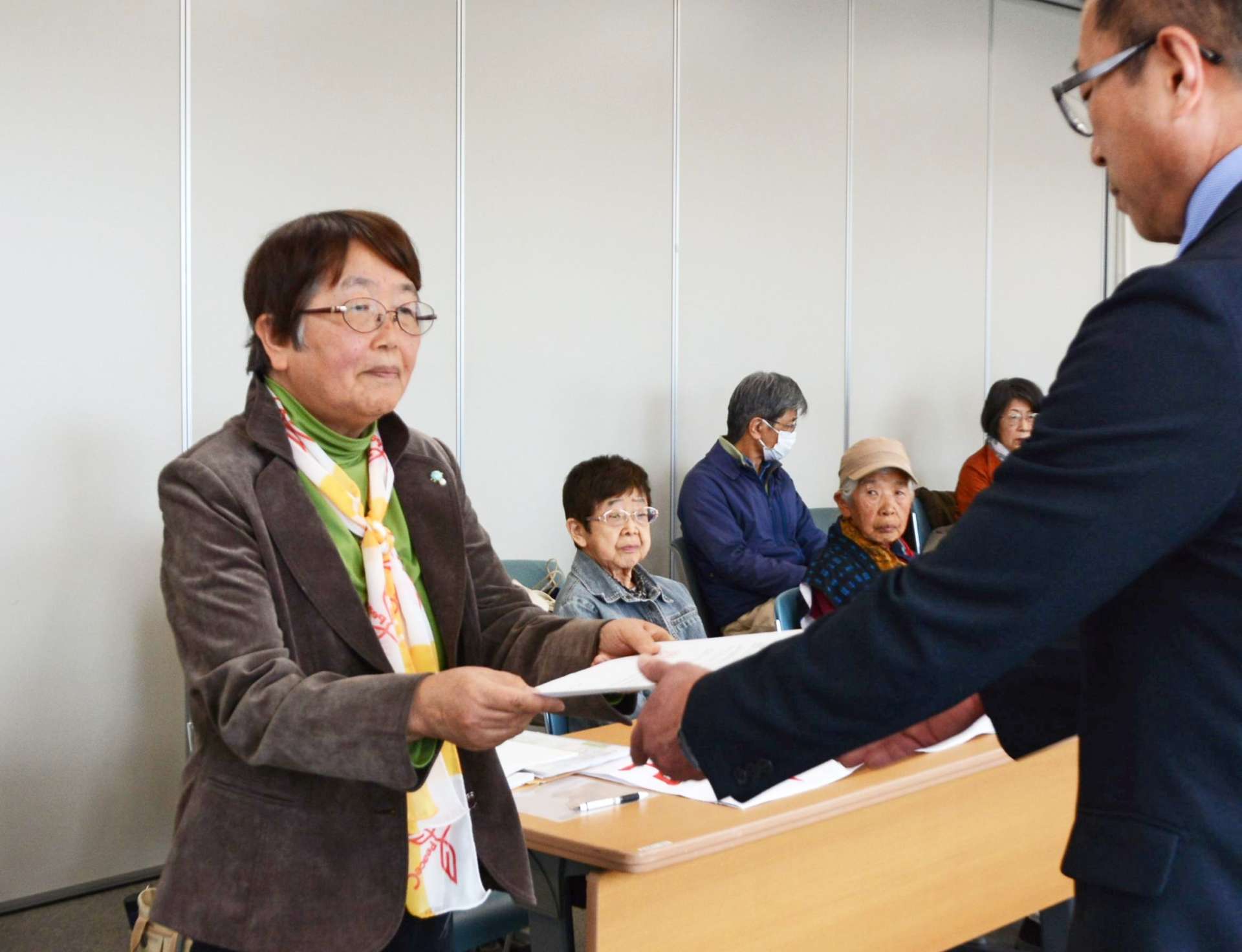 弾薬庫整備中止を求める要請書を手渡す「アイ女性会議鹿児島県本部」の松永三重子議長（左）＝１４日、さつま町役場