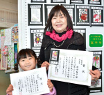 優秀賞を獲得した前田智子さん（右）と孫の原野美怜ちゃん＝伊佐市の本城小学校体育館