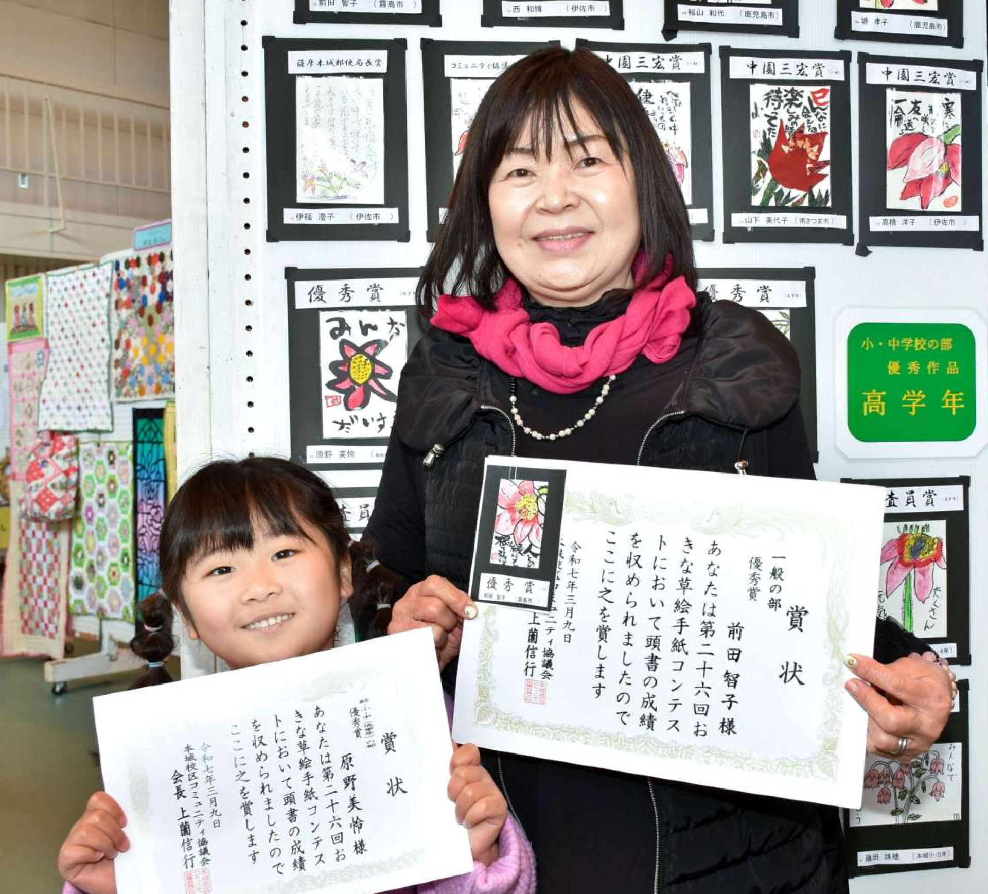 優秀賞を獲得した前田智子さん（右）と孫の原野美怜ちゃん＝伊佐市の本城小学校体育館