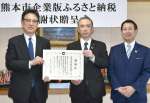 記念撮影をする鹿児島銀行熊本支店の帖佐慎市支店長（中央）＝九州フィナンシャルグループ提供