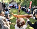 木製の宝船を揺らしながら、手渡しする住民ら＝２０日、日置市吹上の船木神社