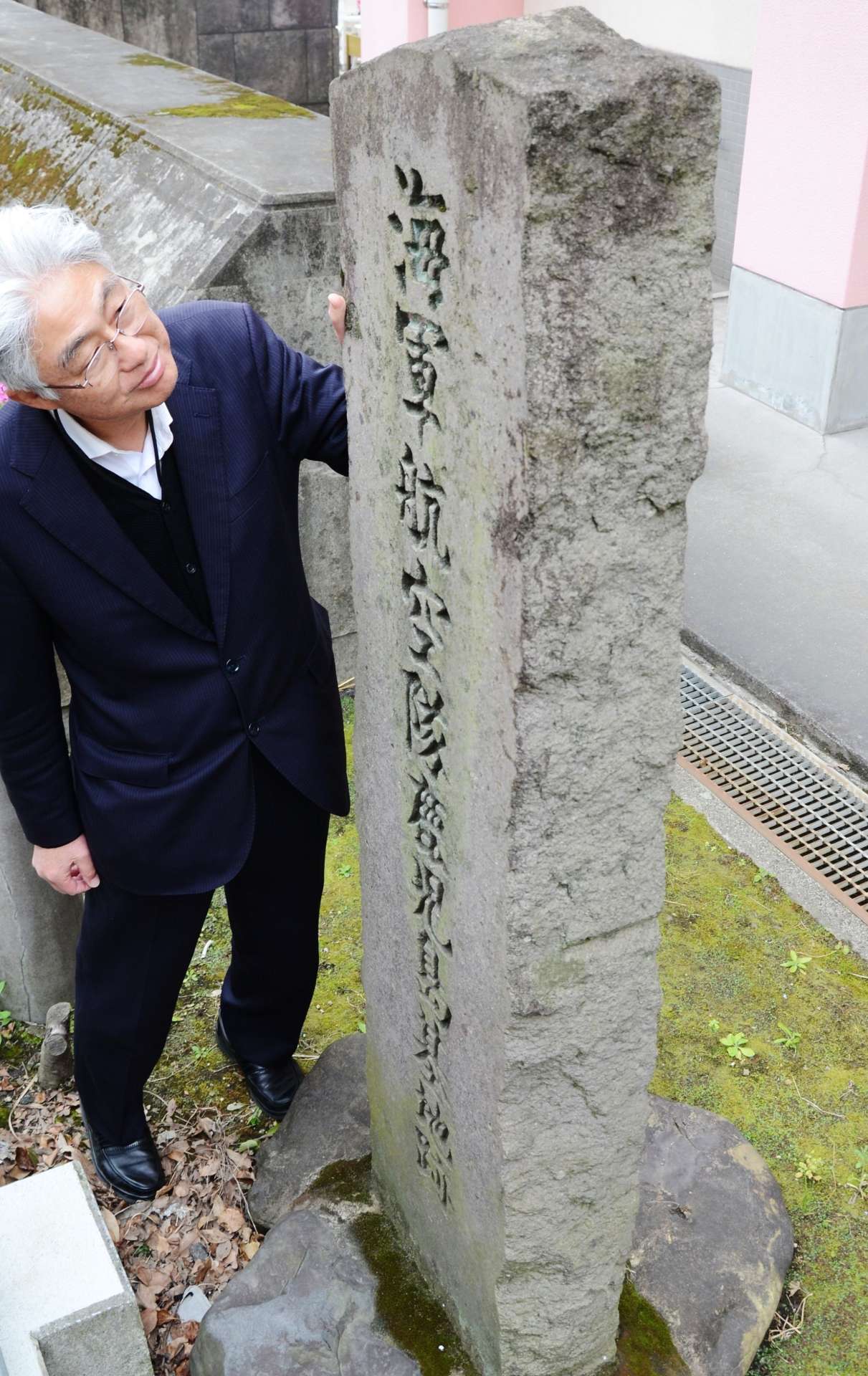 １９６９年、鴨池小学校の創立２０周年にあたって設置された海軍航空隊鹿児島基地跡の石碑。現在は体育館脇にひっそりと立つ＝鹿児島市真砂本町