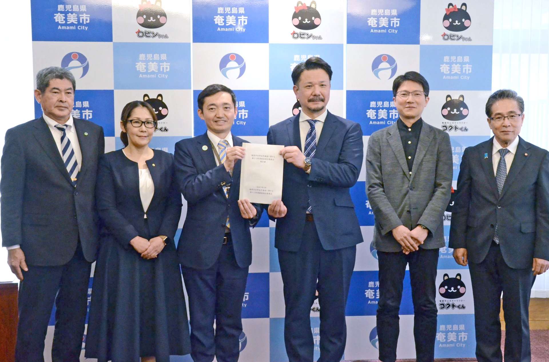 安田壮平市長（左から３人目）に答申する検討会委員＝２１日、奄美市役所