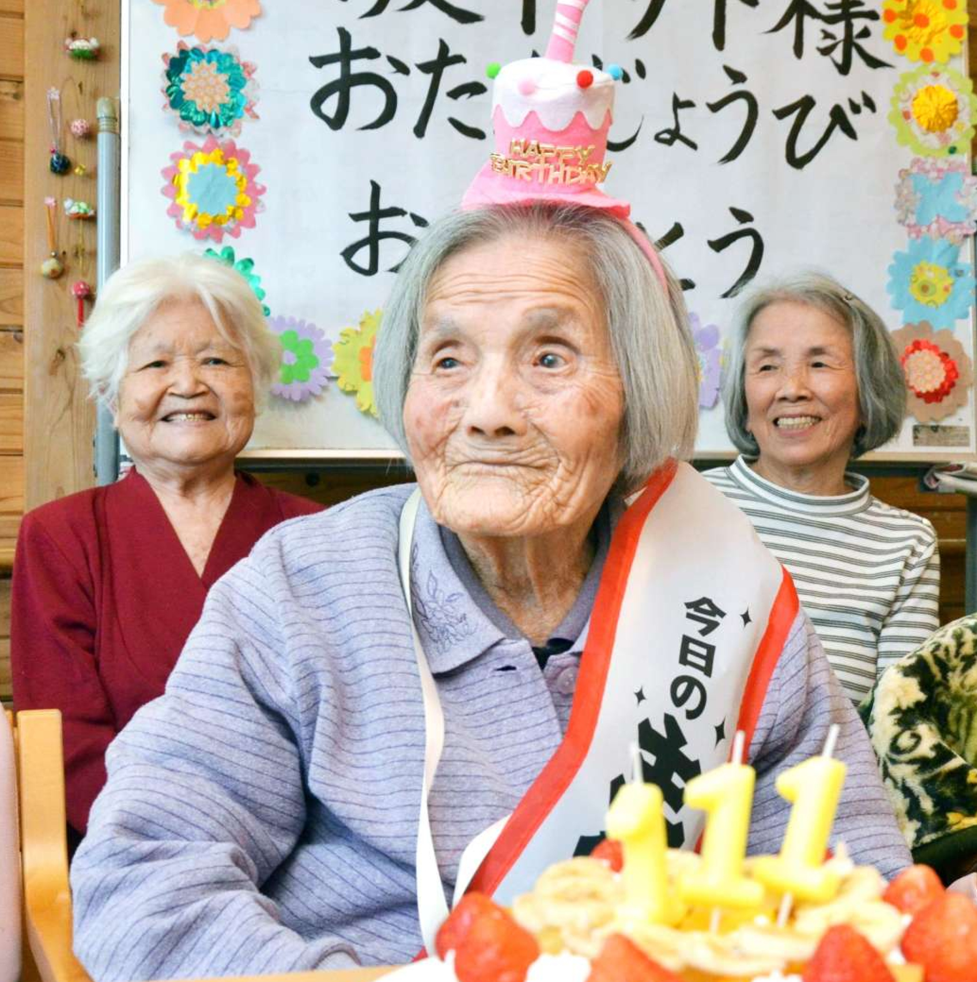 カチューシャを着け、誕生日祝いのケーキを前に笑顔を見せる坂下サトさん＝２０日、鹿児島市星ケ峯２丁目