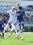 ゴール前で競り合う鹿児島Ｕの岡崎＝鹿児島市の白波スタジアム