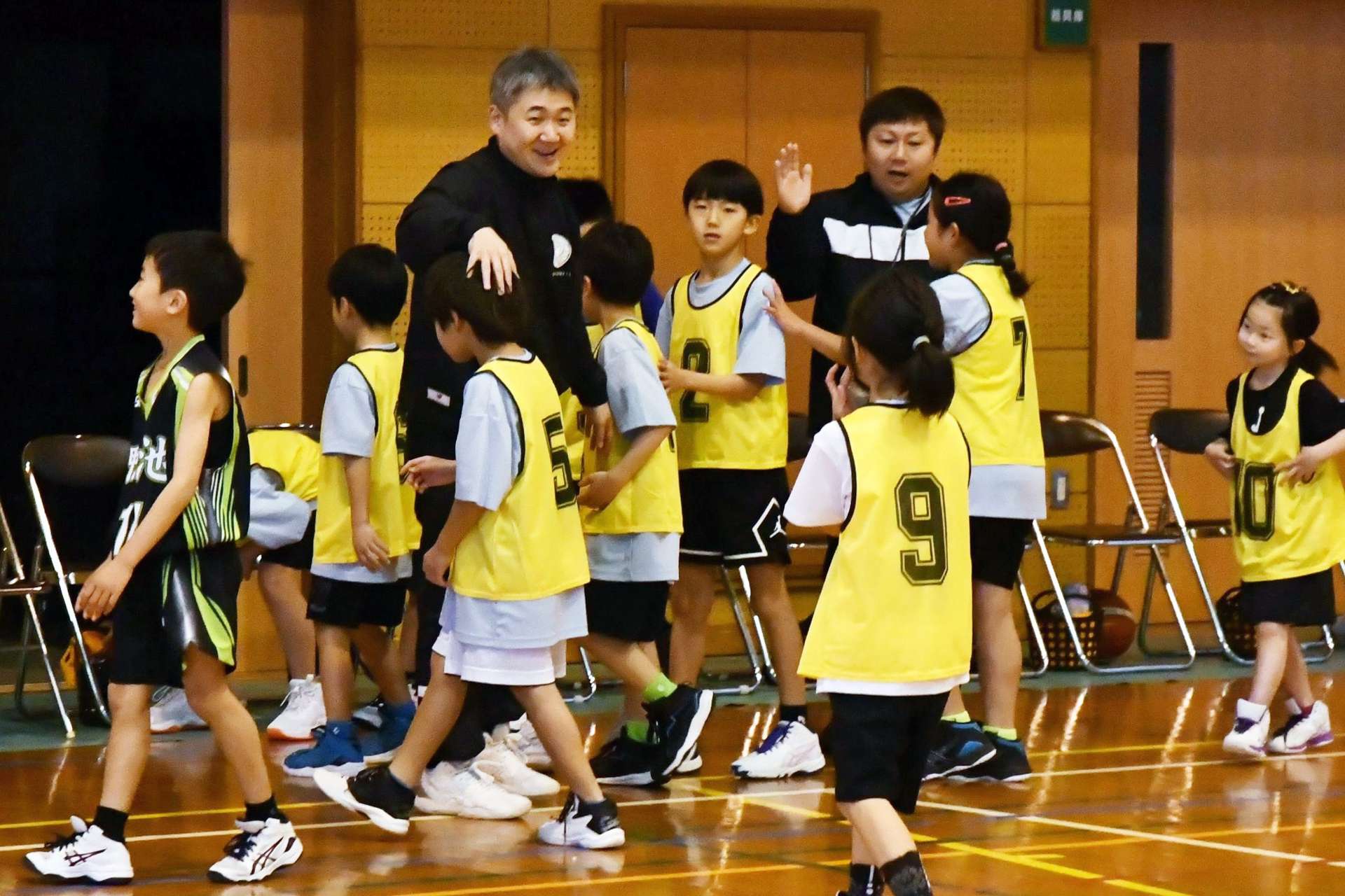 〈関連〉選手を笑顔で迎え入れる指導者＝鹿児島市の広木小学校