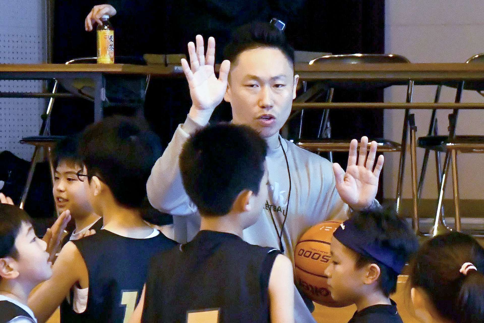 選手をハイタッチで迎え入れる指導者＝鹿児島市の広木小学校