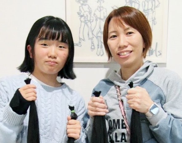 髪の毛を切ったばかりの青山結愛さん（左）と母親の瞳さん＝日置市伊集院
