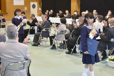 拍手で見送られる大原小学校の卒業生＝２４日、錦江町田代の同校