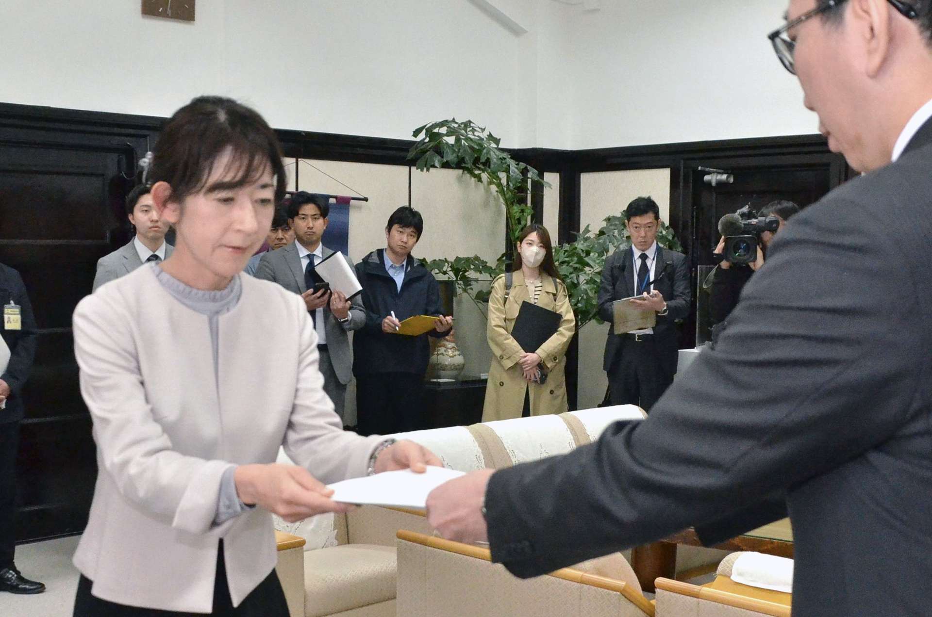 報告書を手渡す松元理恵子委員長＝２４日、鹿児島市役所