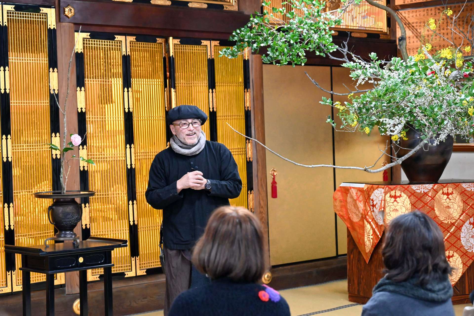 生け花について参拝者と話す上野雄次さん＝南九州市知覧の教行寺
