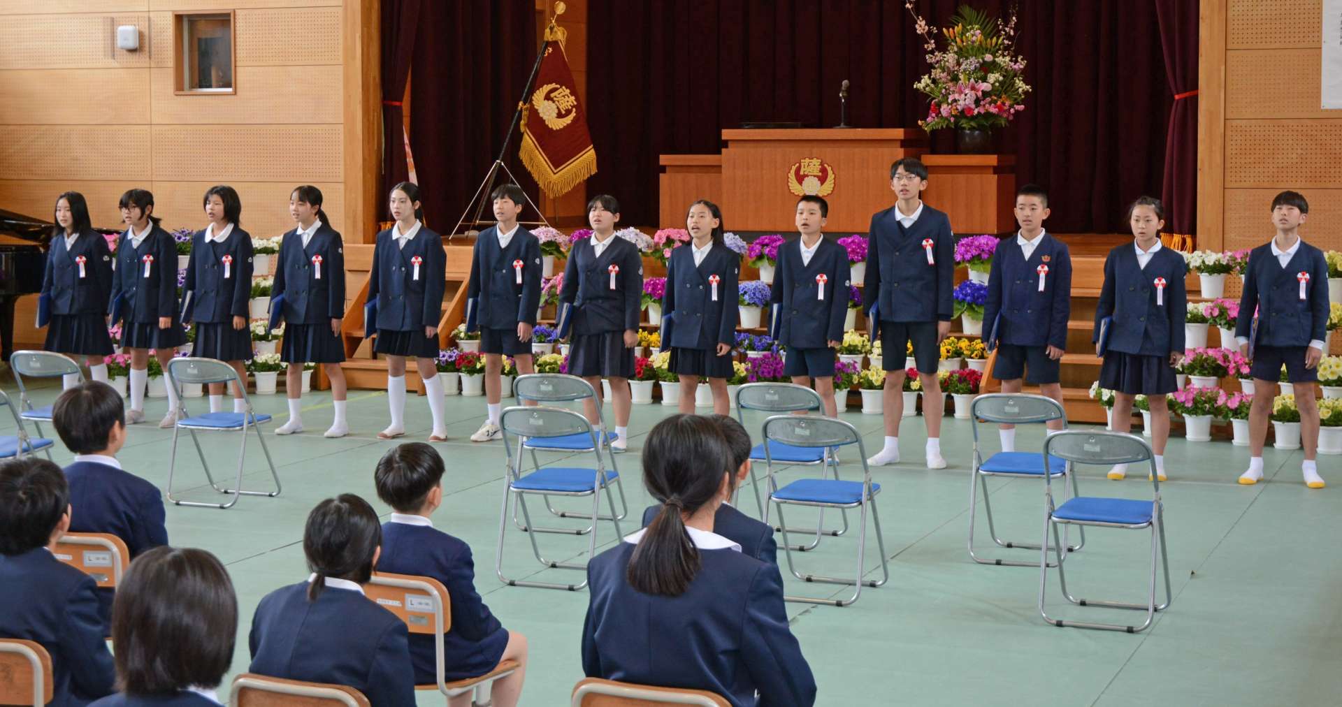在校生らに向かって歌を披露する卒業生＝２４日、さつま町中津川