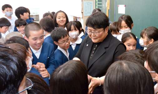 転出する担任の先生と別れを惜しむ児童＝鹿児島市の向陽小学校