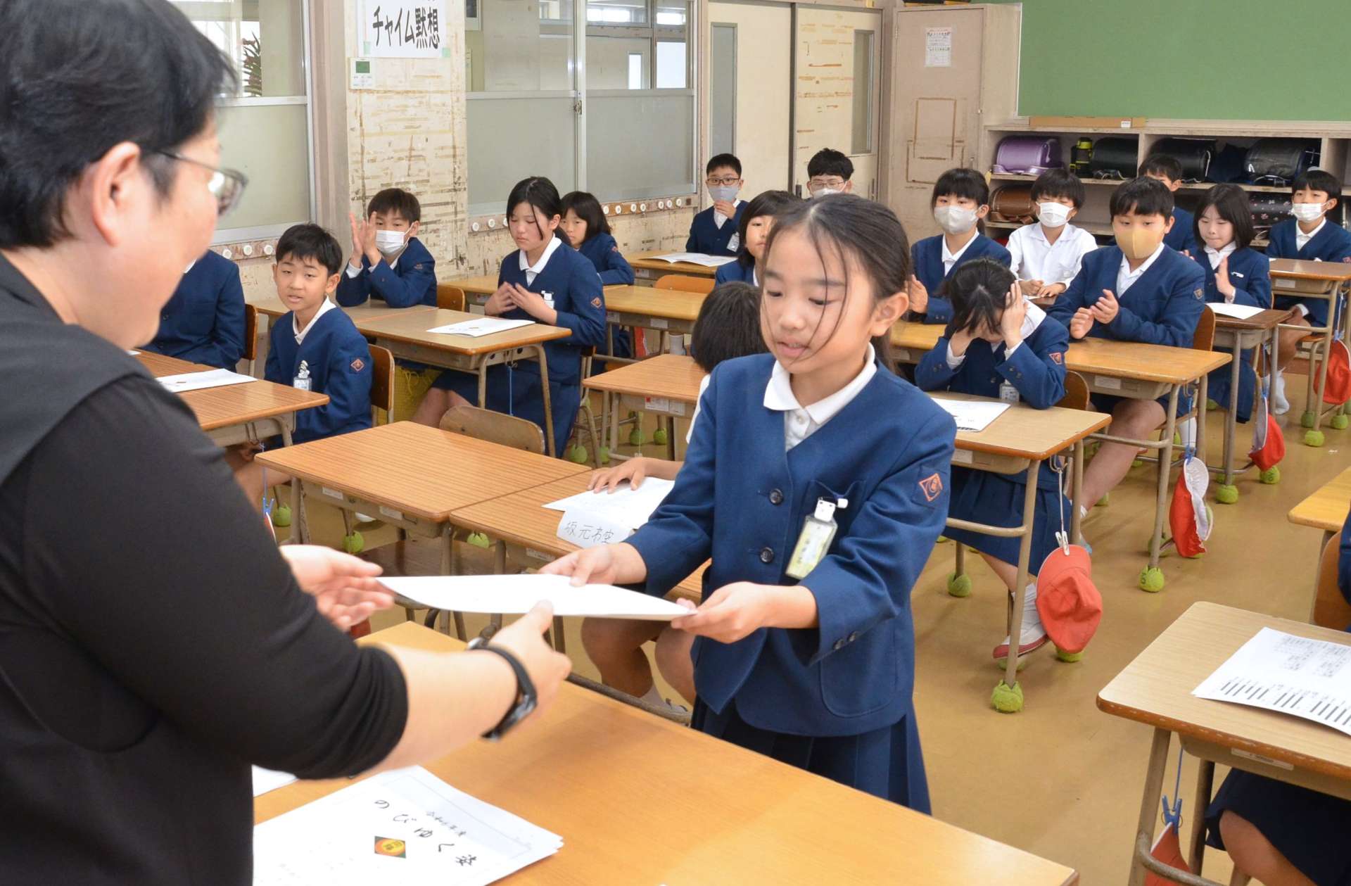 担任から修了証書を受け取る児童＝鹿児島市の向陽小学校