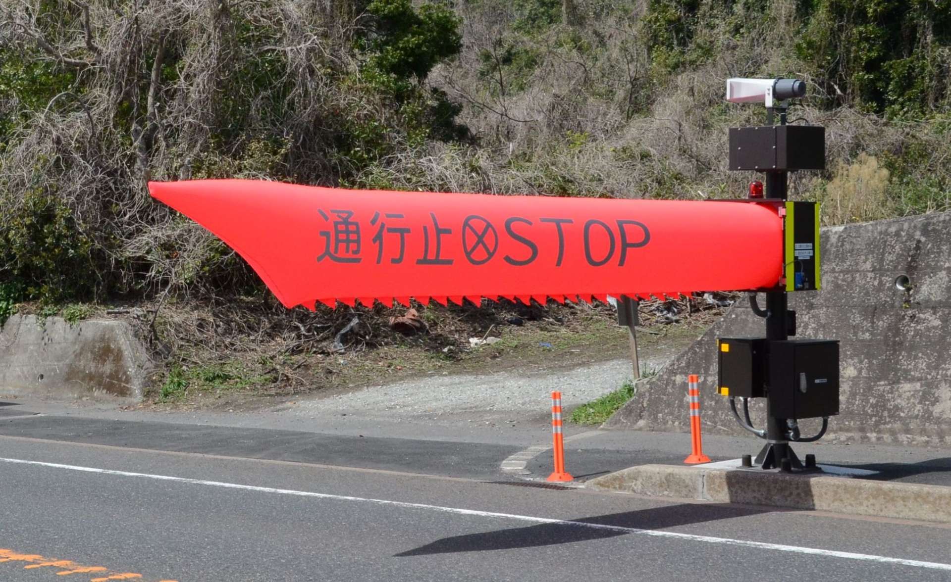 訓練でふくらむエアー式遮断機＝２５日、鹿児島市持木町の国道２２４号