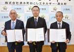 調印する湧水町おこしエネルギーの岡本道暁社長（中央）と池上滝一町長（左）ら＝２５日、湧水町役場