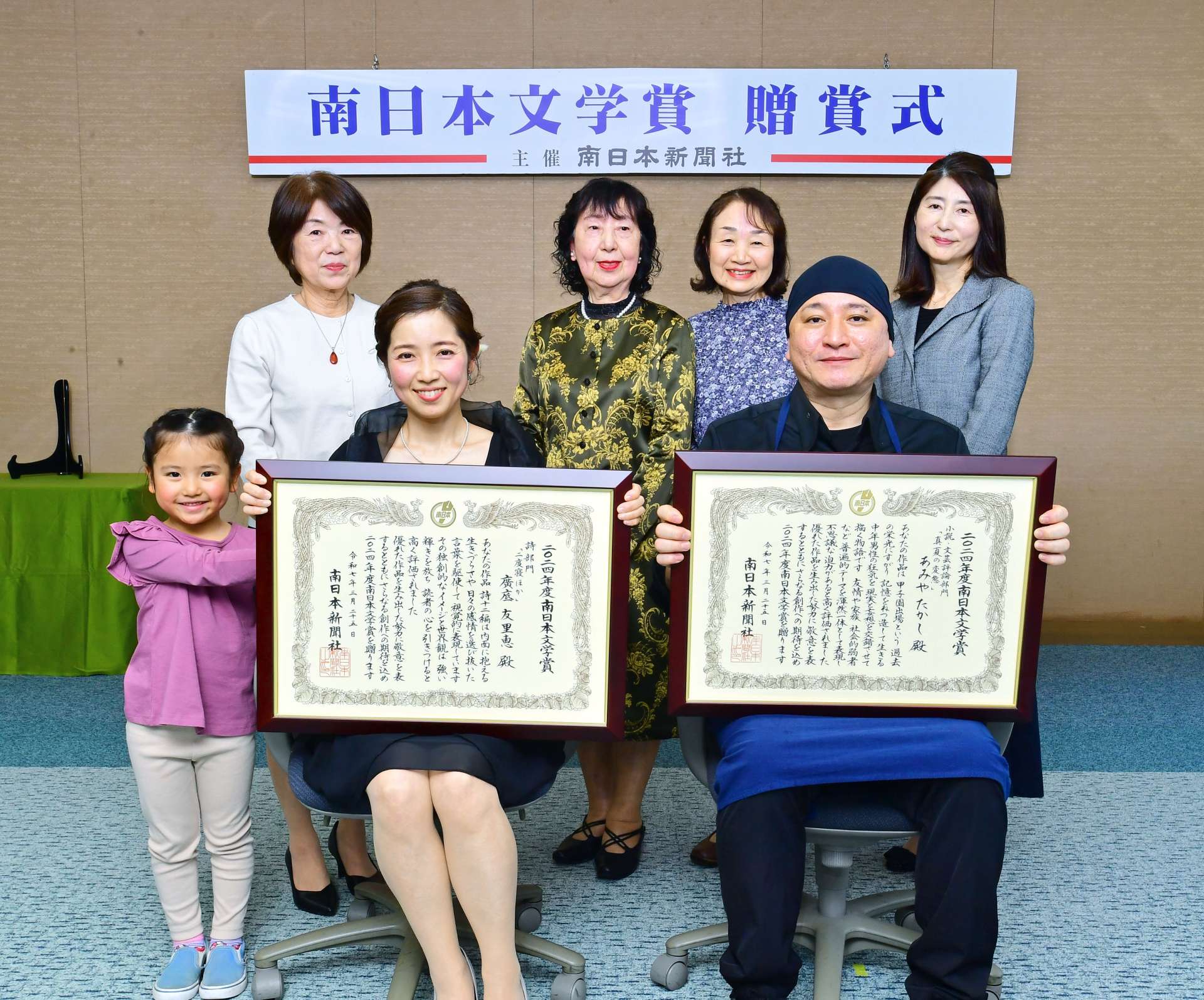 南日本文学賞を受けた小説・文芸評論部門のあみやたかしさん（前列右）と詩部門の広底友里恵さん（同左）＝２５日、鹿児島市の南日本新聞社