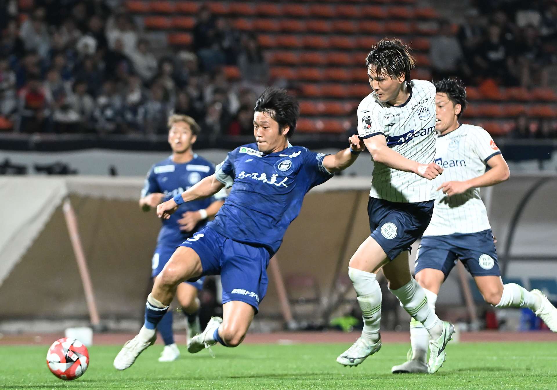 前半、ゴール前に攻め込む鹿児島Ｕの近藤（左）＝鹿児島市の白波スタジアム