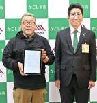 鹿児島市と立地協定を結んだサエッタの平沢久義社長（左）＝２６日、市役所（同市提供）
