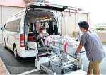 転院する女性を車両に運びこむ民間救急スタッフ＝枕崎市折口町