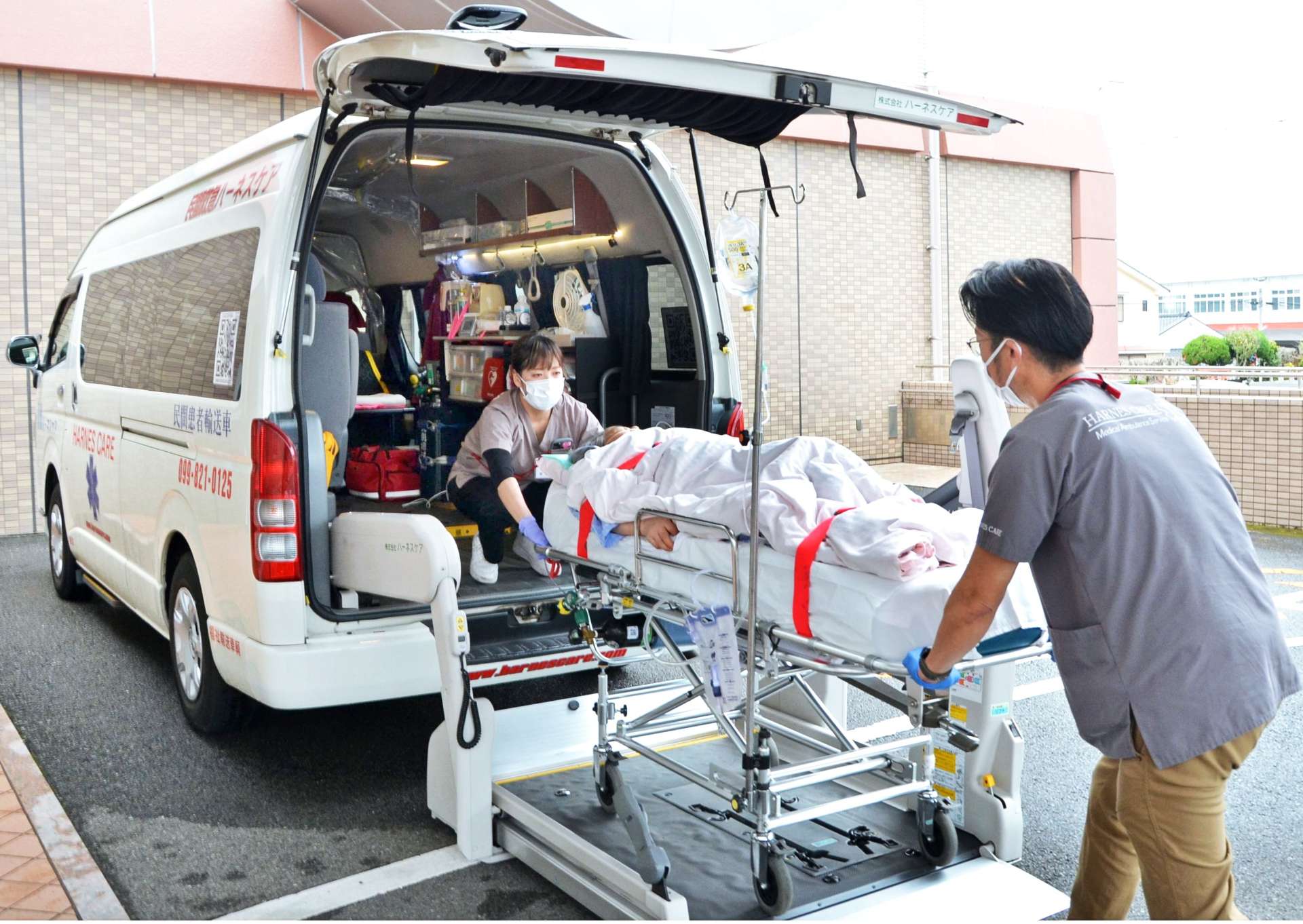 転院する女性を車両に運びこむ民間救急スタッフ＝枕崎市折口町