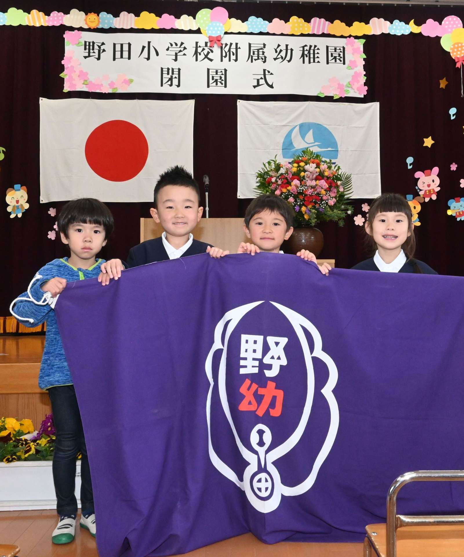 野田小学校付属幼稚園の園旗を手にする卒園児＝出水市野田町上名