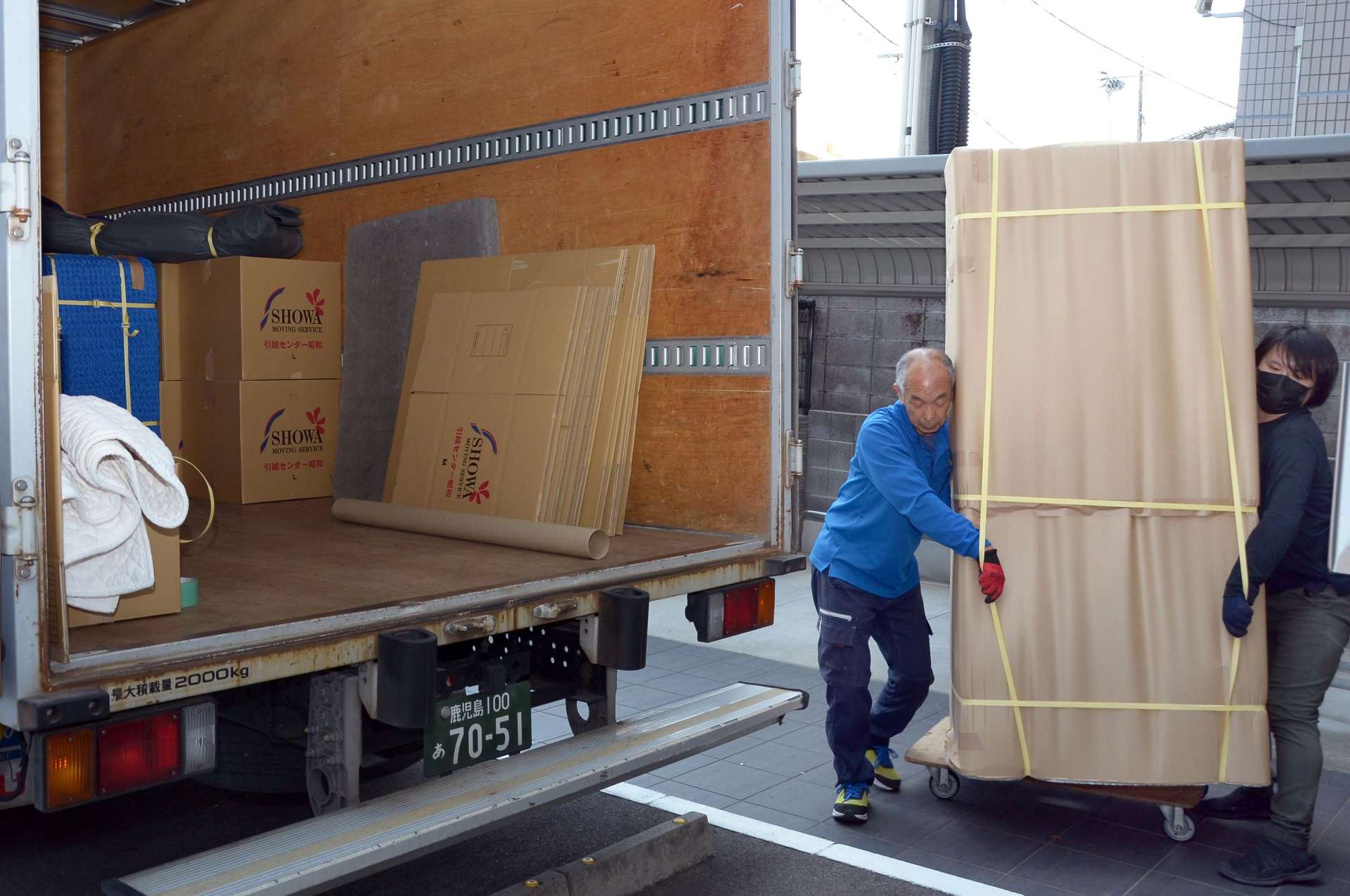 〈別カット〉引っ越しのピークを迎え、慌ただしく作業に追われる現場＝２６日、鹿児島市