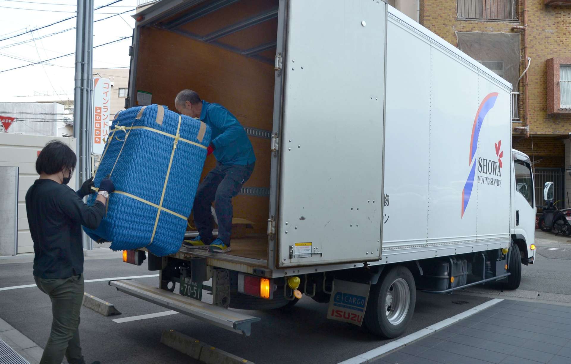 引っ越しのピークを迎え、慌ただしく作業に追われる現場＝２６日、鹿児島市