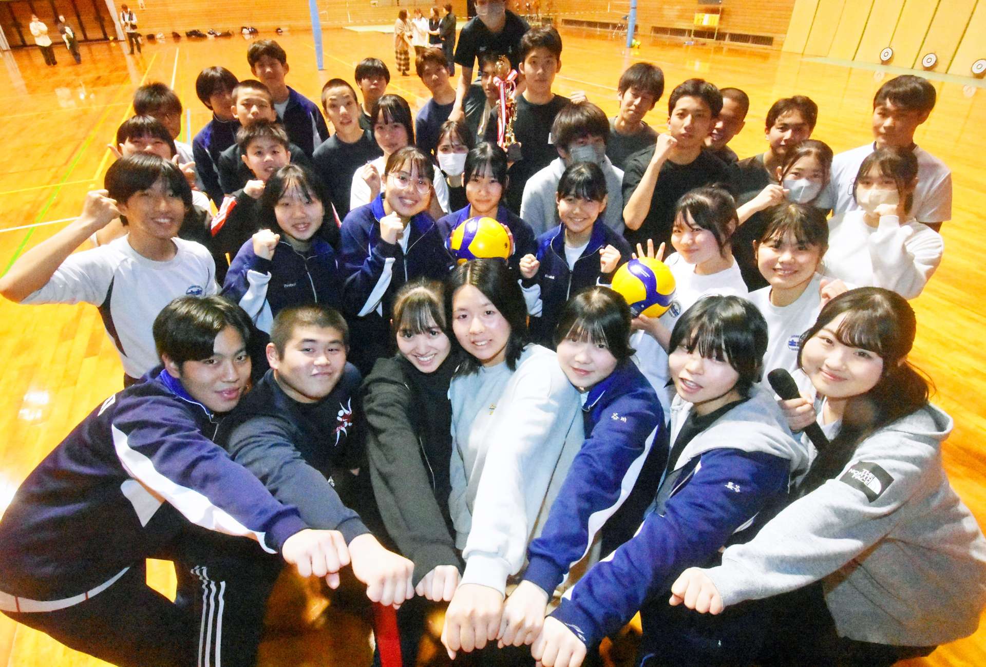 高校に新入学する７人（２列目）との交流会を企画した高校新３年生（前列）＝南さつま市の坊津学園体育館