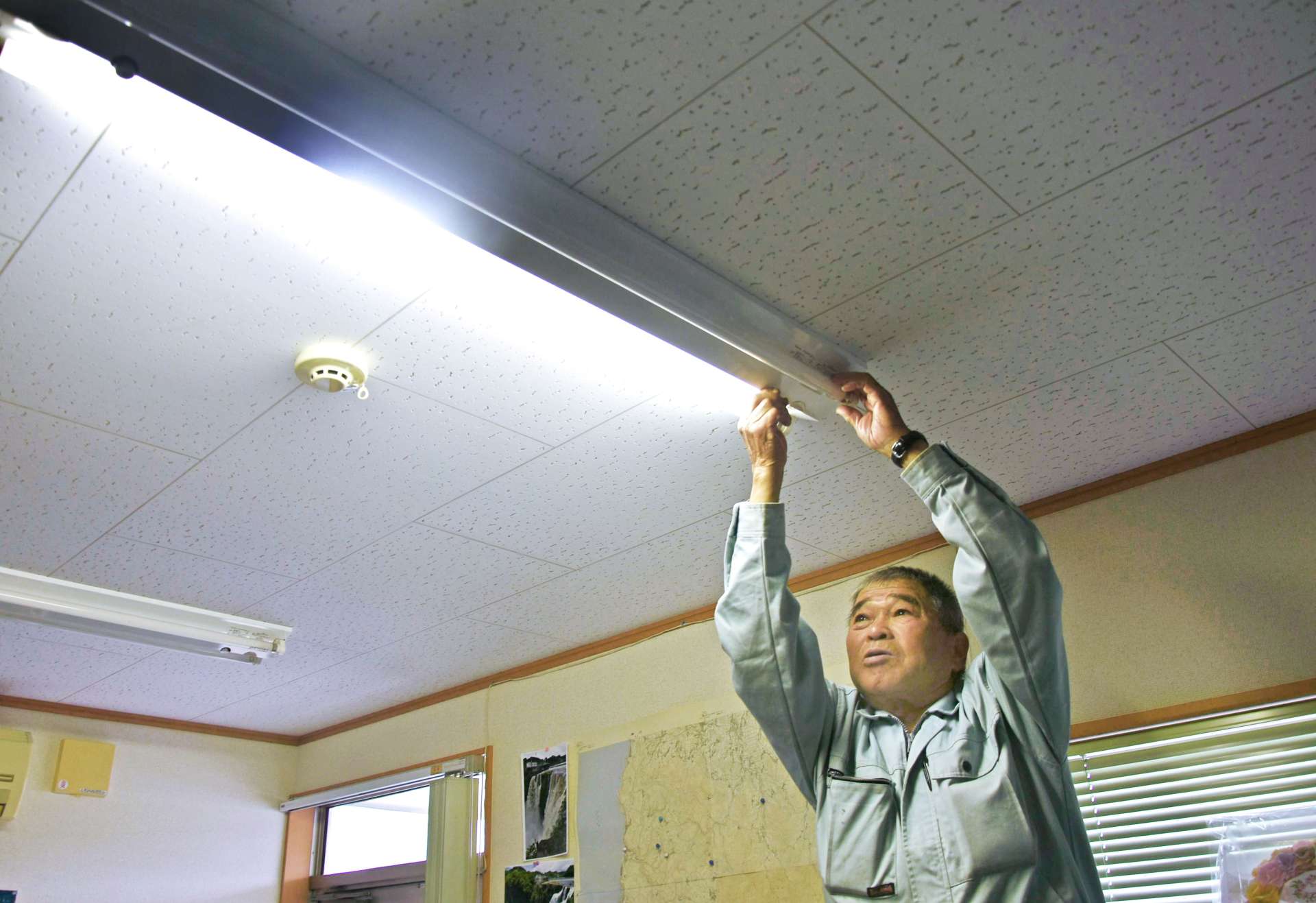 電灯の取り換え作業をする船倉浩さん＝南大隅町根占