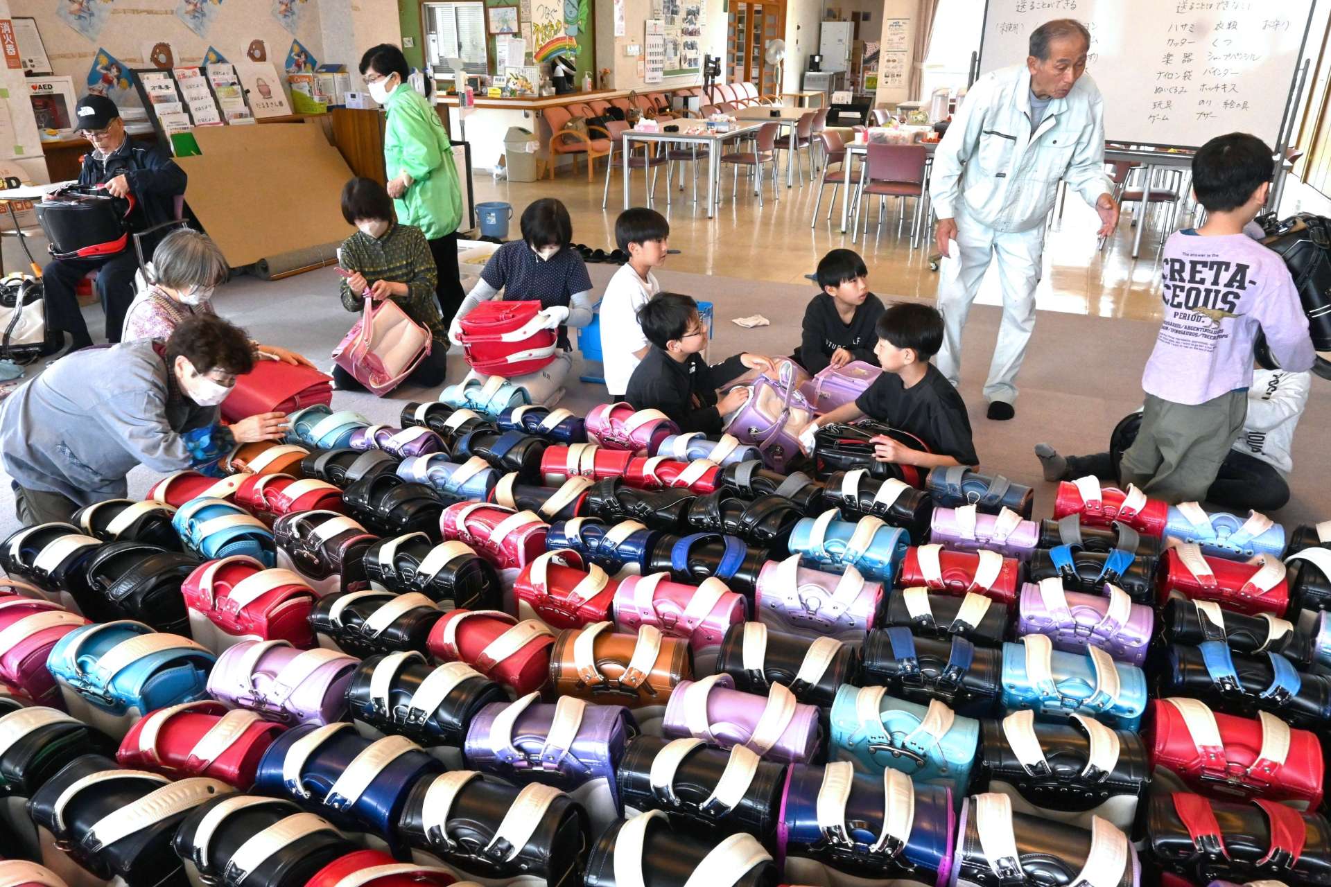 集まったランドセルを検品する参加者＝出水市のたかおの交流館