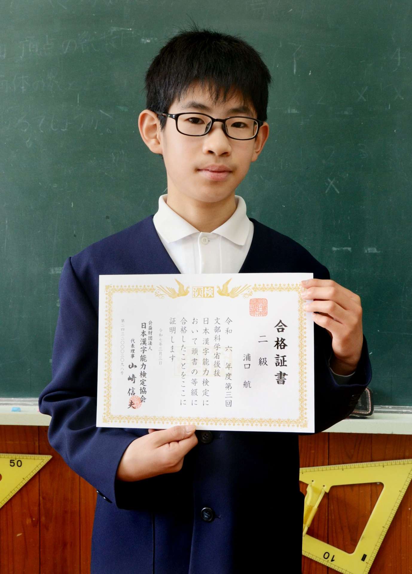 漢検２級合格証書を掲げる浦口航さん＝鹿児島市の黒神小学校
