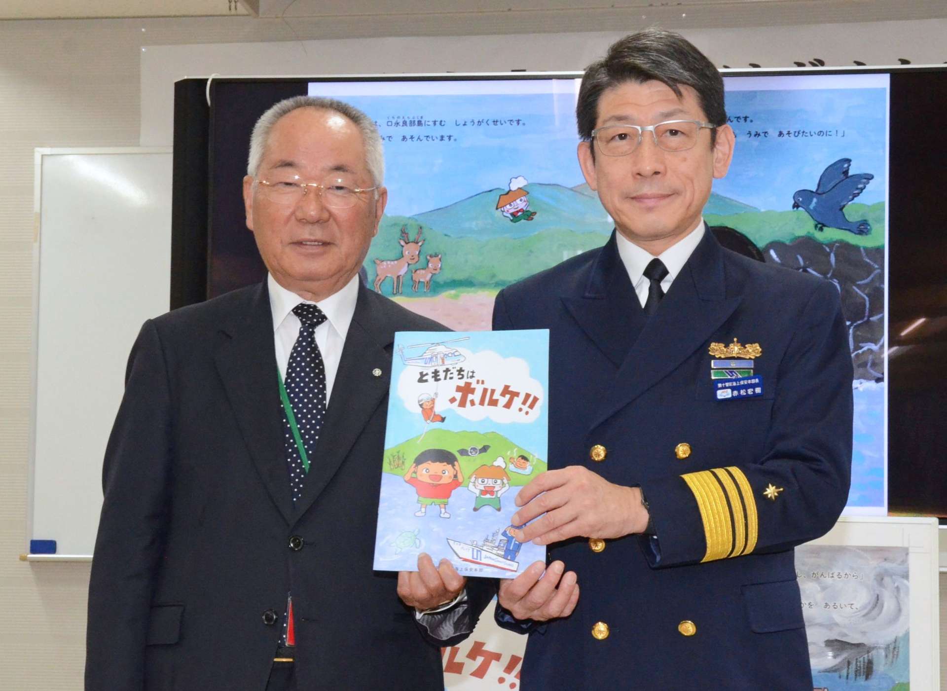 赤松宏樹本部長（右）から絵本を贈呈された荒木耕治町長＝鹿児島市の第１０管区海上保安本部