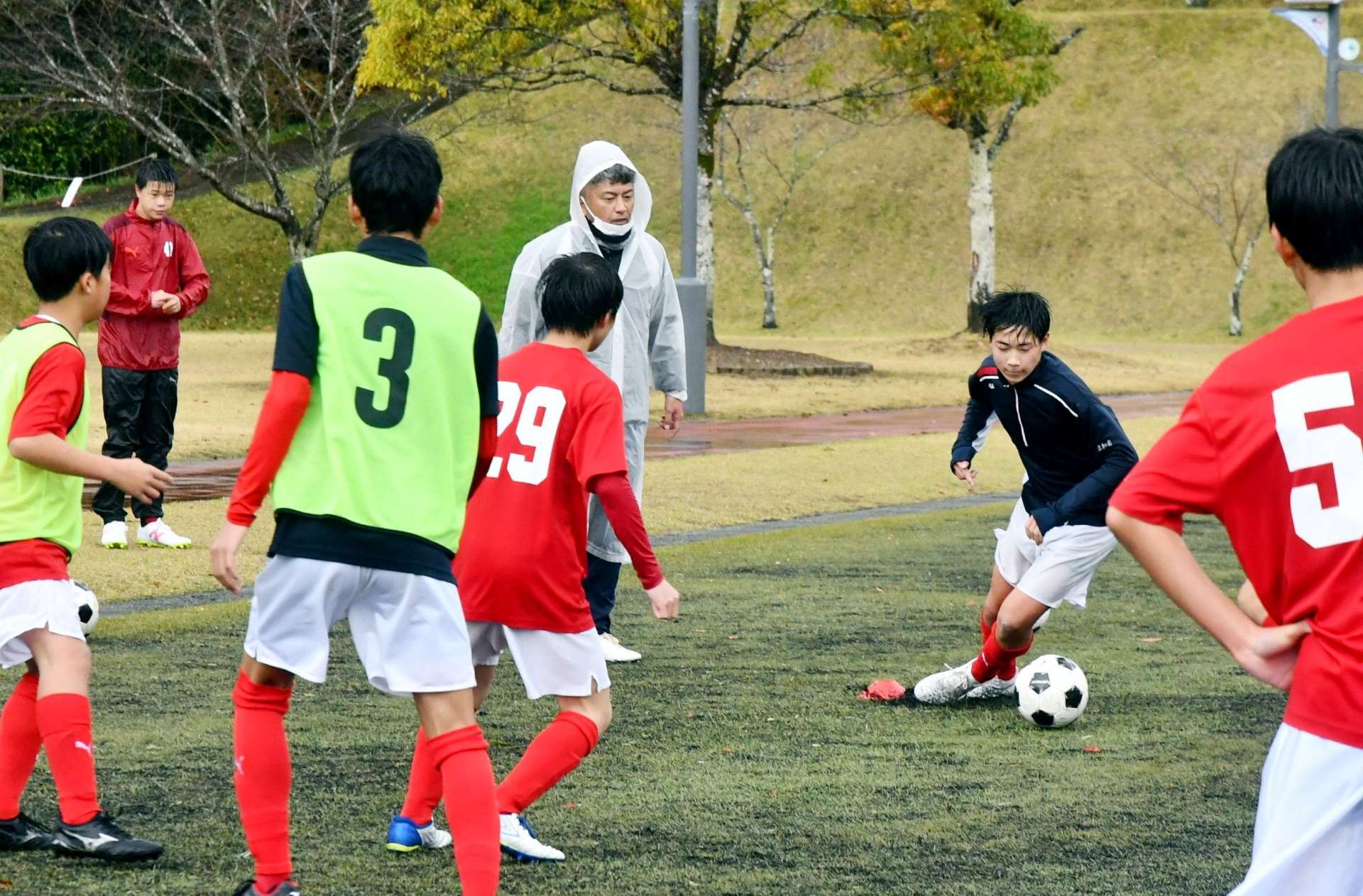 地域指導員の久保譲さん（奥）が関わる樋脇中サッカー部の練習＝薩摩川内市の丸山自然公園
