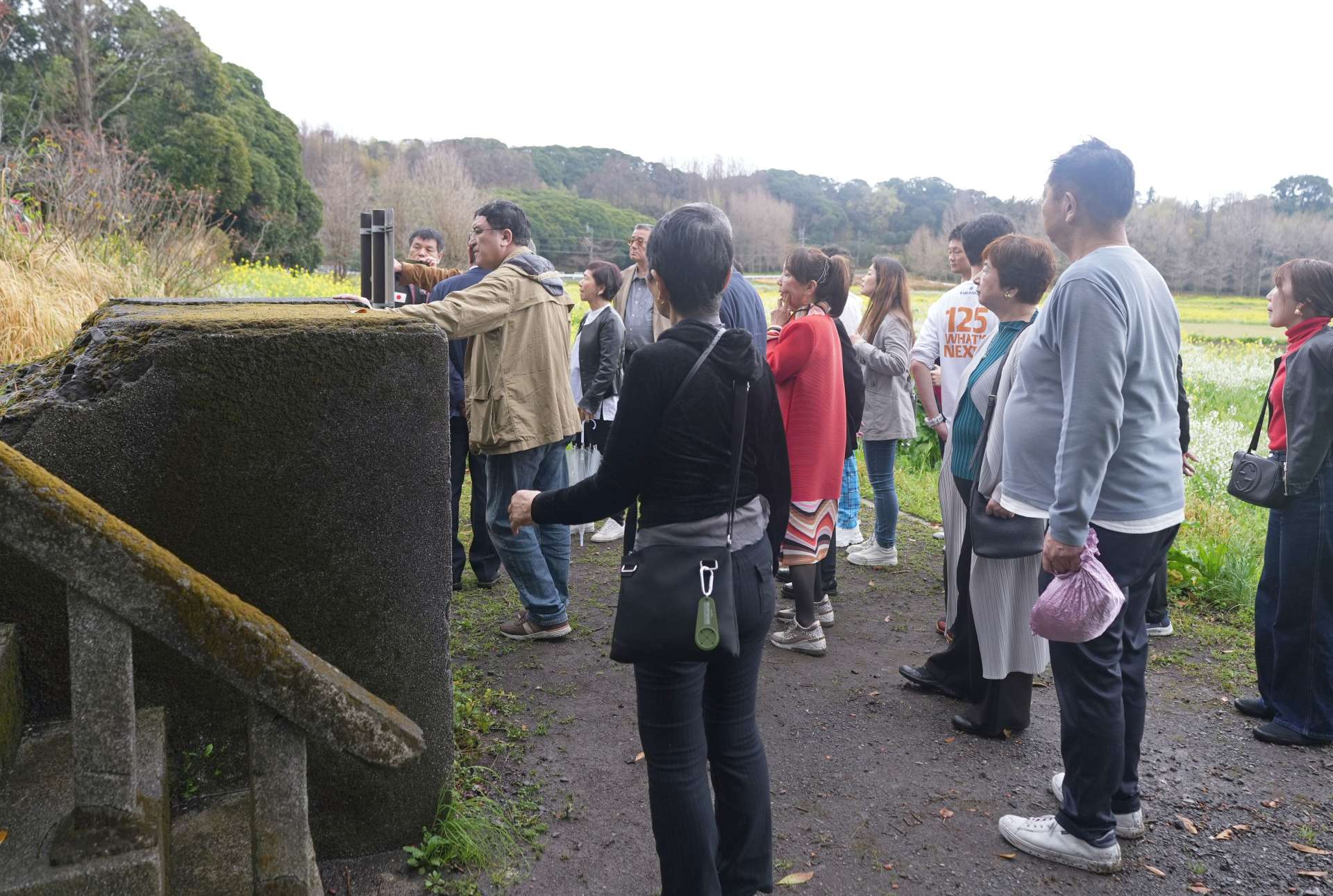 野里国民学校跡を見学する首都圏の経営者ら＝２７日、鹿屋市野里町