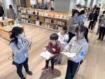 職員の案内で図書館を見学する小学生＝３月２９日、鹿児島市の天文館図書館