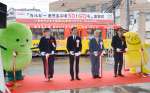 カルビー鹿児島工場操業５０周年を記念したラッピング電車の出発を祝う、久保進工場長（左から２人目）ら＝１日、鹿児島市交通局