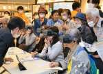 ＶＲ機材を装着し、介護映像を体験する来場者。多くの人が訪れ、関心の高さを感じさせる＝鹿児島市の天文館図書館