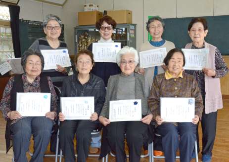 表彰状を受け取り記念撮影する「水曜会」のメンバー＝３月２６日、鹿児島市明和５丁目の永吉団地親和会館