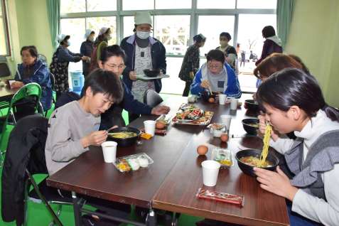 熱々のラーメンをすする蔵之元地区の住民ら＝３月３０日、長島町の蔵之元公民館